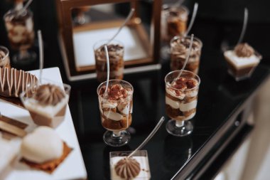 Bir parti için çeşitli pasta ve pastalar da dahil olmak üzere bir masa dolusu tatlı hazırlanıyor.