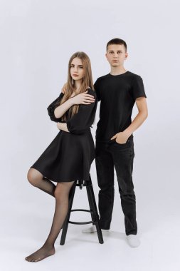 Bir adam ve bir kadın siyah giysiler içinde yan yana duruyorlar. İkisi de resim için poz veriyor.