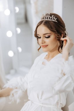 Taçlı ve beyaz cüppeli bir kadın kanepede oturur. Kadın resmi ve asil bir şekilde giyindiği için zarafet ve entelektüellik kavramı