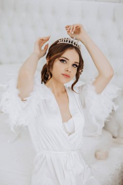 Beyaz bornoz ve taç giyen bir kadın. O bir resim için poz veriyor. Zarafet ve incelik kavramı