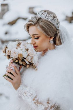 Bir gelin elinde bir buket çiçek tutuyor ve beyaz bir kürk manto giyiyor. O bir taç takıyor ve saçları topuz şeklinde. Sahne karlı bir ortamda geçiyor, bu da romantizmi arttırıyor.