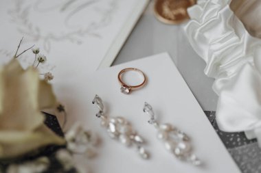 Yüzük ve küpeler beyaz bir kartta.