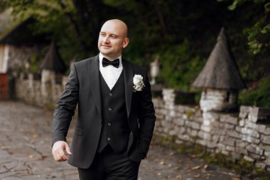 Takım elbiseli ve kravatlı bir adam yolda yürüyor. Gülümsüyor ve mutlu.