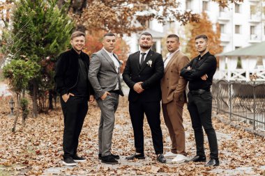 Takım elbiseli ve kravatlı bir grup adam fotoğraf için poz veriyor. Sahne resmi ve profesyoneldir.