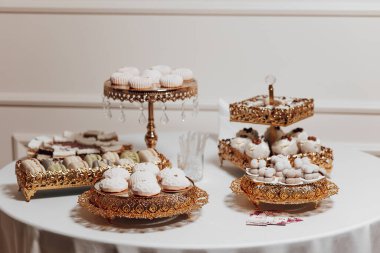 İçinde çörekler ve çörekler de olan çeşitli tatlıların olduğu bir masa. Masa özel bir durum için hazırlandı ve tatlılar görsel olarak çekici ve davetkar bir şekilde düzenlendi.