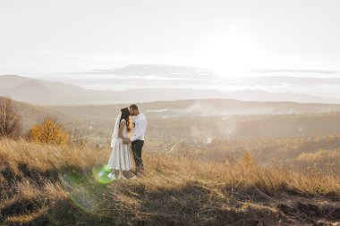 Çimenli bir yamaçta bir çift öpüşüyor. Güneş parıldıyor, sıcak ve romantik bir atmosfer yaratıyor. Çift beyaz giyinmiş, bu da sahnedeki saflık ve aşkı arttırıyor.