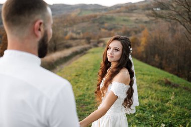 Gelin ve damat tarlada duruyorlar, gelin kameraya bakıyor. Sahne romantik ve mutlu, çünkü çift evleniyor.