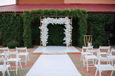 Çiçekli beyaz bir kemer bir binanın önünde.