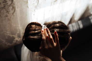 Kafasında çörek olan bir kadın saçına dokunuyor. Kadın ve izleyici arasındaki samimiyet ve yakınlık kavramı