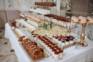 Pasta, kek ve diğer tatlı ikramları içeren bir masa dolusu tatlı.