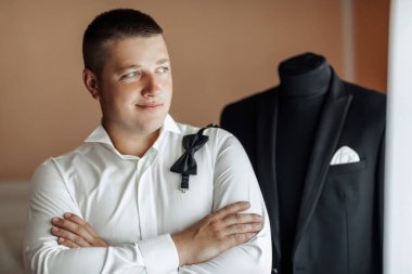 Takım elbiseli bir adam siyah takım elbiseli bir mankenin önünde duruyor.