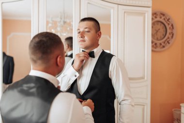 İki adam bir yatak odasında giyiniyor.