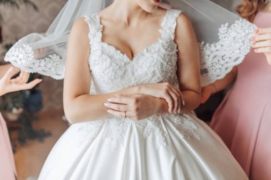 Bir gelin düğünü için hazırlanıyor ve nedimeleri duvağı için ona yardım ediyor.