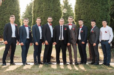 Takım elbiseli ve kravatlı bir grup adam fotoğraf için poz veriyor. Sahne resmi ve profesyoneldir.