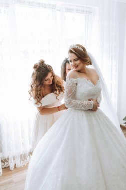 Bir gelin, nedimeleri ona yardım ederken düğününe hazırlanıyor. Gelin uzun beyaz bir elbise ve bir taç giyiyor. Sahne neşeli ve kutlayıcıdır.