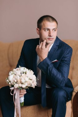 Takım elbiseli bir adam elinde bir buket çiçekle kanepede oturur. Derin düşüncelere dalmış, muhtemelen geleceğini ya da çiçeklerin anlamını düşünüyordur. Düşünce ve içgözlem kavramı