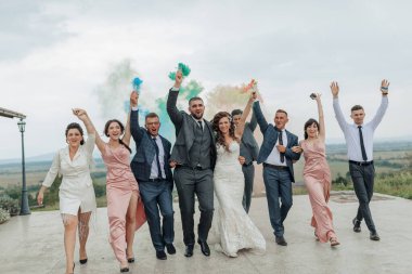 Bir grup insan bir düğünü kutluyor. Gelin ve damat da grubun ortasında.