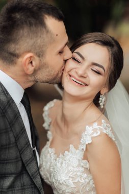 Bir gelin ve damat birbirlerinin dudaklarını öpüyor.