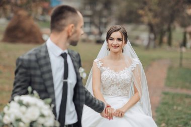 Bir gelin ve damat el ele tutuşarak yolda yürüyorlar. Gelin beyaz bir elbise ve duvak takıyor. Sahne bir düğün ve çift birlikte özel günlerinin tadını çıkarıyor.