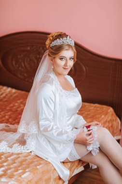 Beyaz elbiseli bir kadın elinde kırmızı bir gülle yatakta oturuyor. O bir taç ve bir peçe takıyor, ve onun saçı bir topuz şeklinde. Zarafet ve incelik kavramı