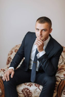 Takım elbiseli ve kravatlı bir adam kanepede oturuyor, düşünceli görünüyor. İş adamı takım elbise ve kravat giydiği için profesyonellik ve entelektüellik kavramı. Kanepe biraz rahatlık katıyor.