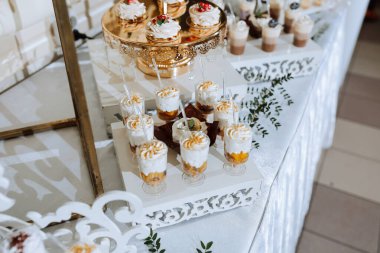 Kekler ve kekler de dahil olmak üzere çeşitli tatlılar içeren bir masa bir parti için hazırlandı.