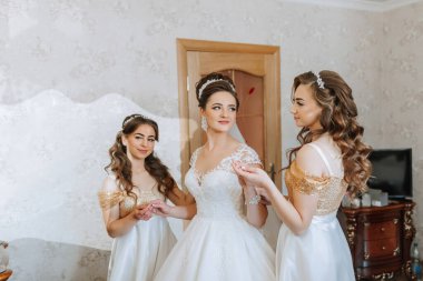 Üç kadın düğün için hazırlanıyor. İçlerinden biri altın bir elbise giyiyor. Diğer ikisi beyaz elbiseler giyiyor. Aynanın önünde duruyorlar, büyük olaya hazırlanıyorlar.