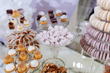 Pastalar, kekler ve kurabiyelerle dolu bir masa. Tatlılar, onları kuleye benzetecek şekilde düzenlenmiş.