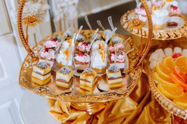 Altın çerçeveli bir tepsi tatlı ve çikolata, vanilya ve çilek gibi çeşitli tatlar.