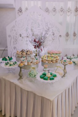 Kekler ve kurabiyeler de dahil olmak üzere çeşitli tatlılar içeren bir masa bir parti için hazırlanır.