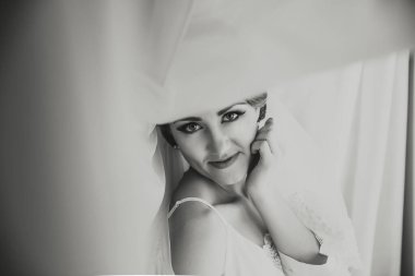 Bir kadın peçe takıyor ve kameraya bakıyor. Gülümsüyor ve mutlu.