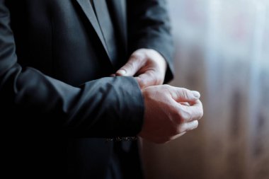 Takım elbiseli bir adam ceketini ayarlıyor. Formalite ve profesyonellik kavramı