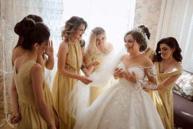 Bir gelin, tüm sarı elbiseler giyen nedimeleriyle çevrilidir. Gelin gülümsüyor ve anın tadını çıkarıyor.