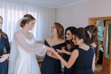 Bir gelin ve nedimeleri bir odada toplanırlar. Gelin beyaz bir elbise ve duvak takarken nedimeler siyah giyiniyor. Hepsi gülümsüyor.