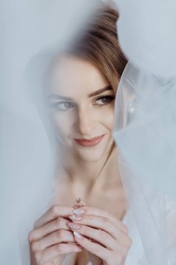 Bir kadın elinde bir yüzük tutuyor ve gülümsüyor. Yüzük parmağında ve perdeden görülebiliyor. Mutluluk ve aşk kavramı, kadının taktığı alyans gibi.