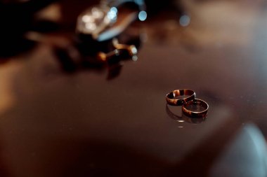 Masada iki altın alyans var. Yüzükler üst üste konur ve birbirlerine dokunmazlar.