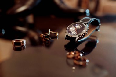 Masada bir saat ve bir yüzük var. Saat bir Rolex ve yüzük de altın bir yüzük.