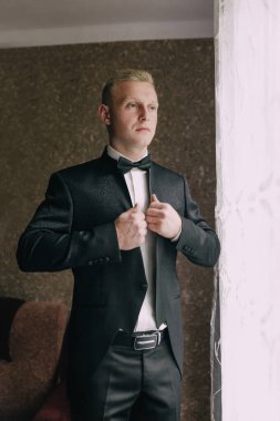 Takım elbiseli bir adam papyonunu bağlamaya hazırlanıyor. Formalite ve zarafet kavramı. Çünkü adam smokin giymiş ve özel bir etkinliğe hazırlanıyor.