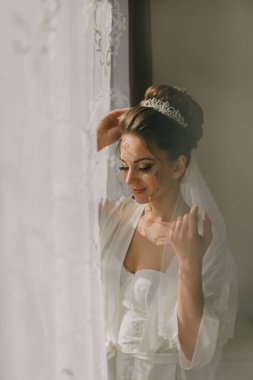 Beyaz cüppeli bir kadın pencerenin önünde oturuyor, saçını tarıyor. O bir taç ve bir peçe takıyor, ve onun saçı bir topuz şeklinde. Zarafet ve incelik kavramı