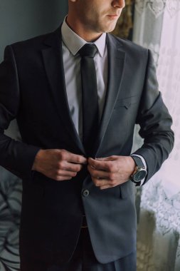 Takım elbiseli bir adam kravatını düzeltiyor. Formalite ve profesyonellik kavramı