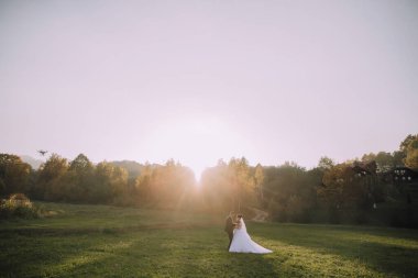 Bir çift, güneş üzerlerine doğarken bir tarlada duruyor. Sahne huzurlu ve romantikti. Çift birbirlerinin gözlerinin içine bakıyordu.