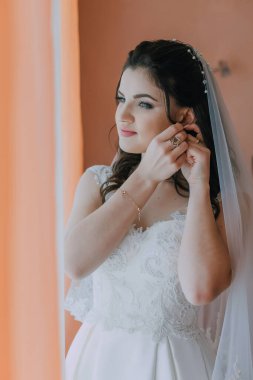 Bir kadın düğün için hazırlanıyor ve alyansını takıyor. Aynada kendine bakıyor ve keyfi yerinde.