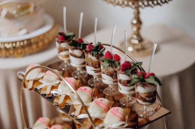 Bir tepsi kek ve bir tepsi browni de dahil olmak üzere çeşitli tatlılar içeren bir masa.