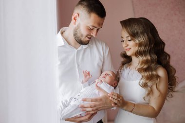 Bir adam ve bir kadın kucağında bir bebek taşıyor. - Bebek uyuyor. Sahne sıcak ve sevgi dolu.