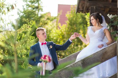 Gelin ve damat ahşap bir merdivende el ele tutuşuyorlar. Gelin beyaz bir elbise ve duvak giyerken damat takım elbise ve kravat takıyor. Sahne yemyeşil bir ormanda geçiyor.