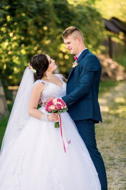 Gelin ve damat bir tarlada birlikte duruyorlar, gelin bir buket çiçek tutuyor. Sahne mutlu ve kutlama dolu, çünkü çift evleniyor.