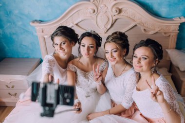 Bir grup kadın bir resim için poz veriyor ve biri diğerinin fotoğrafını çekiyor.
