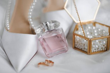 Bir çift beyaz ayakkabı, bir şişe parfüm ve bir kutu inciyle. Zarafet ve incelik kavramı