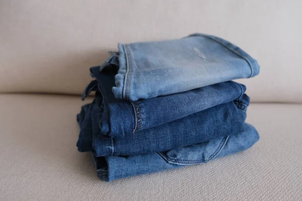 Jeansowe Spodnie Różne Kolory Składanych Ułożonych Dżinsowych Spodni Białej Sofie — Zdjęcie stockowe