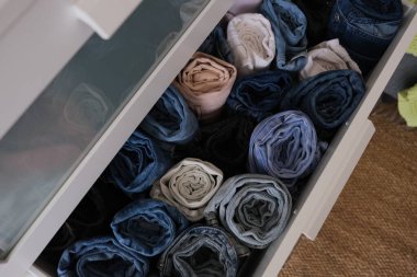 Bir sandık dolusu sarılmış kot pantolon, açık çekmece dolusu sarılmış kot pantolon, yakın plan. Çapraz çerçeve fikir fotoğrafı.